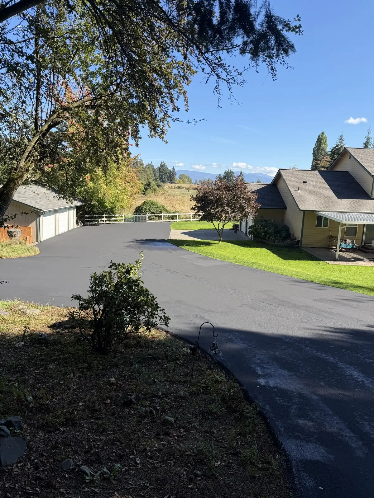 The finished turnaround, sealed deep black, with the house and valley view behind.